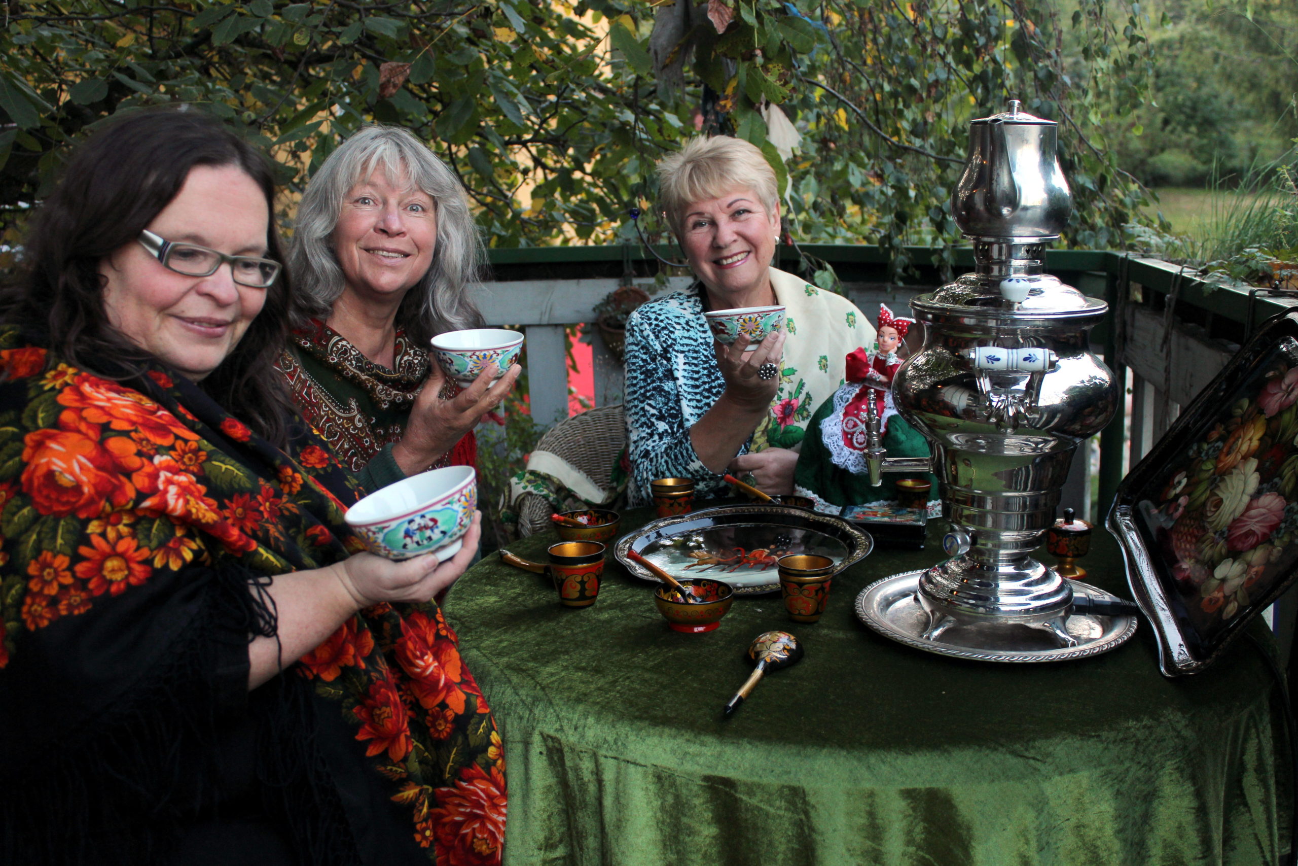 Drei Frauen beim Teetrinken. Auf dem Tisch steht ein Samowar.