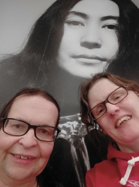 Julia und Bettina vor dem Ausstellungsplakat mit Yoko Ono
