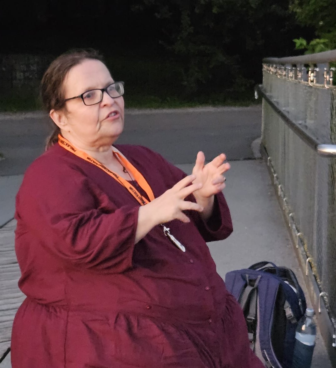 Halbprofil Von Bettina in dunkelroter Bluse beim Erzählen
