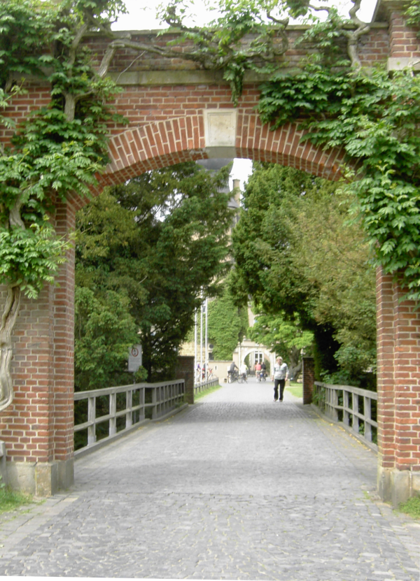 Der schnurgerade, gepflasterte Weg durch das Tor aus Ziegelsteinen führt zur Burg